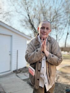A White person with a shaved head smiles at the camera while outside. Queer teens in St. Louis can chill and create in a silly way with this local artist at a Proud Art event in June 2026.